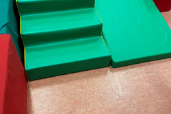Treppe und Rampe aus grünen Bausteinen in einer Turnhalle 